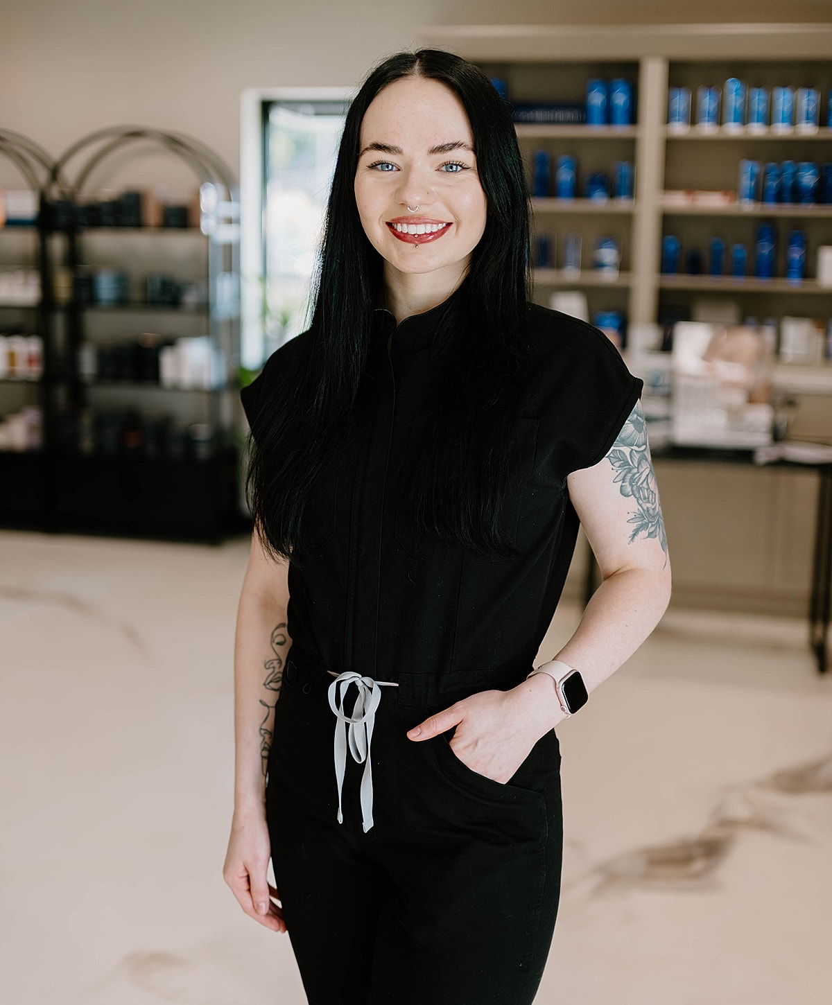 Professional woman in black outfit, smiling.