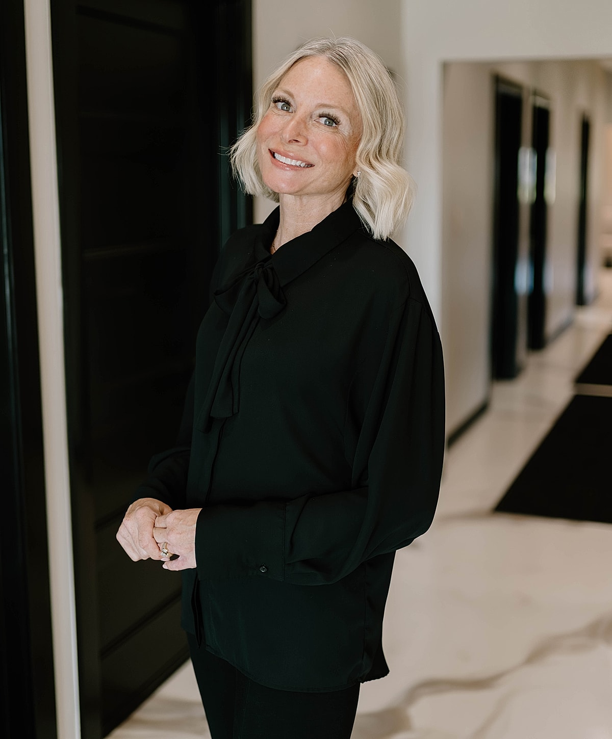 Smiling woman wearing a black blouse indoors.