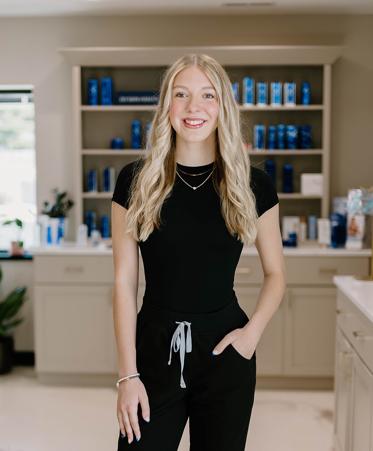 Smiling woman in casual attire, beauty salon background.