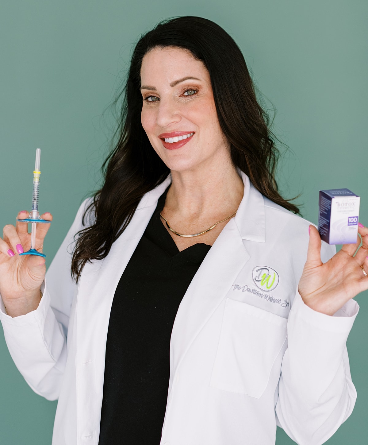 Healthcare professional holding syringe and product box.