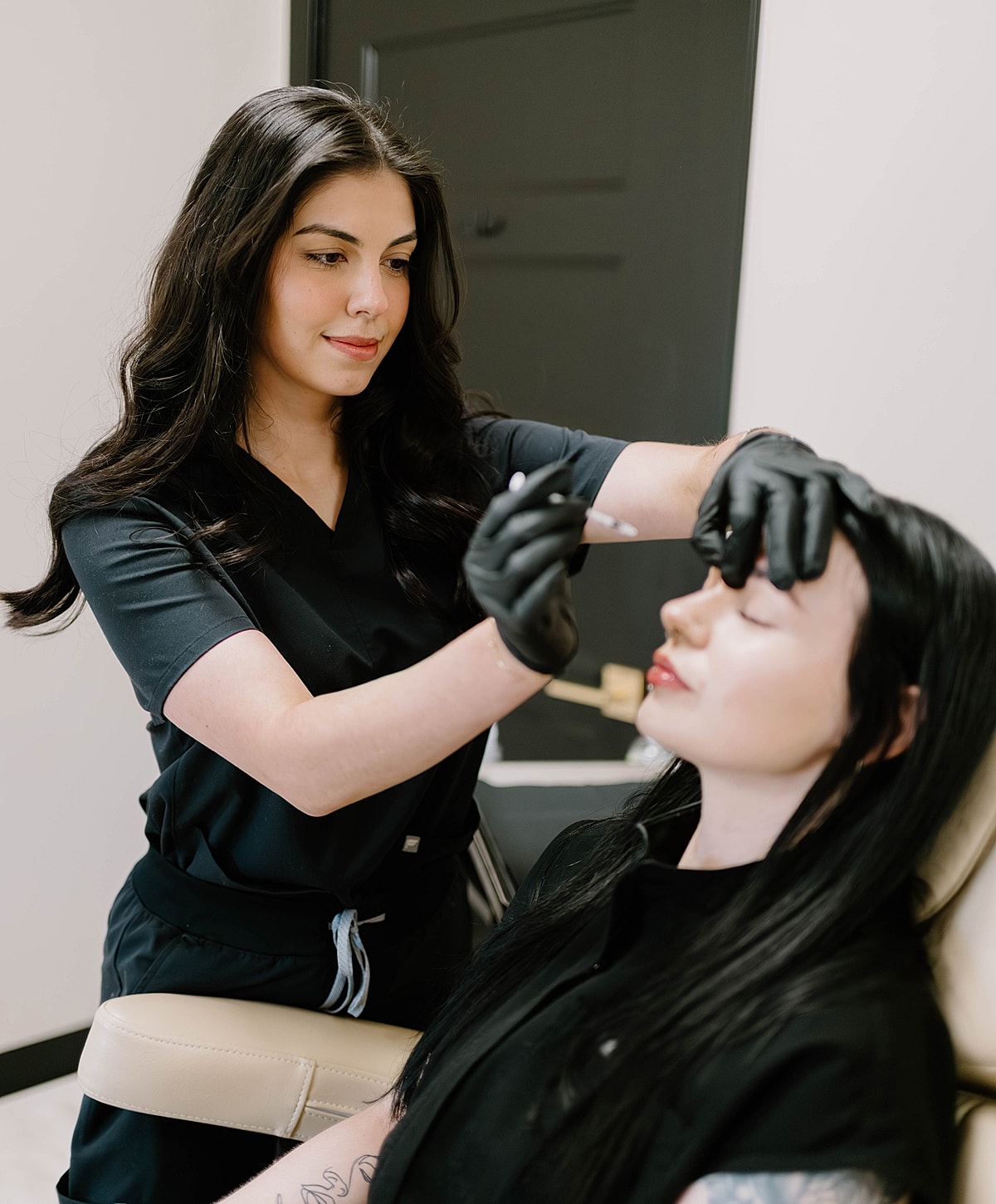 Beauty professional administering treatment to client.
