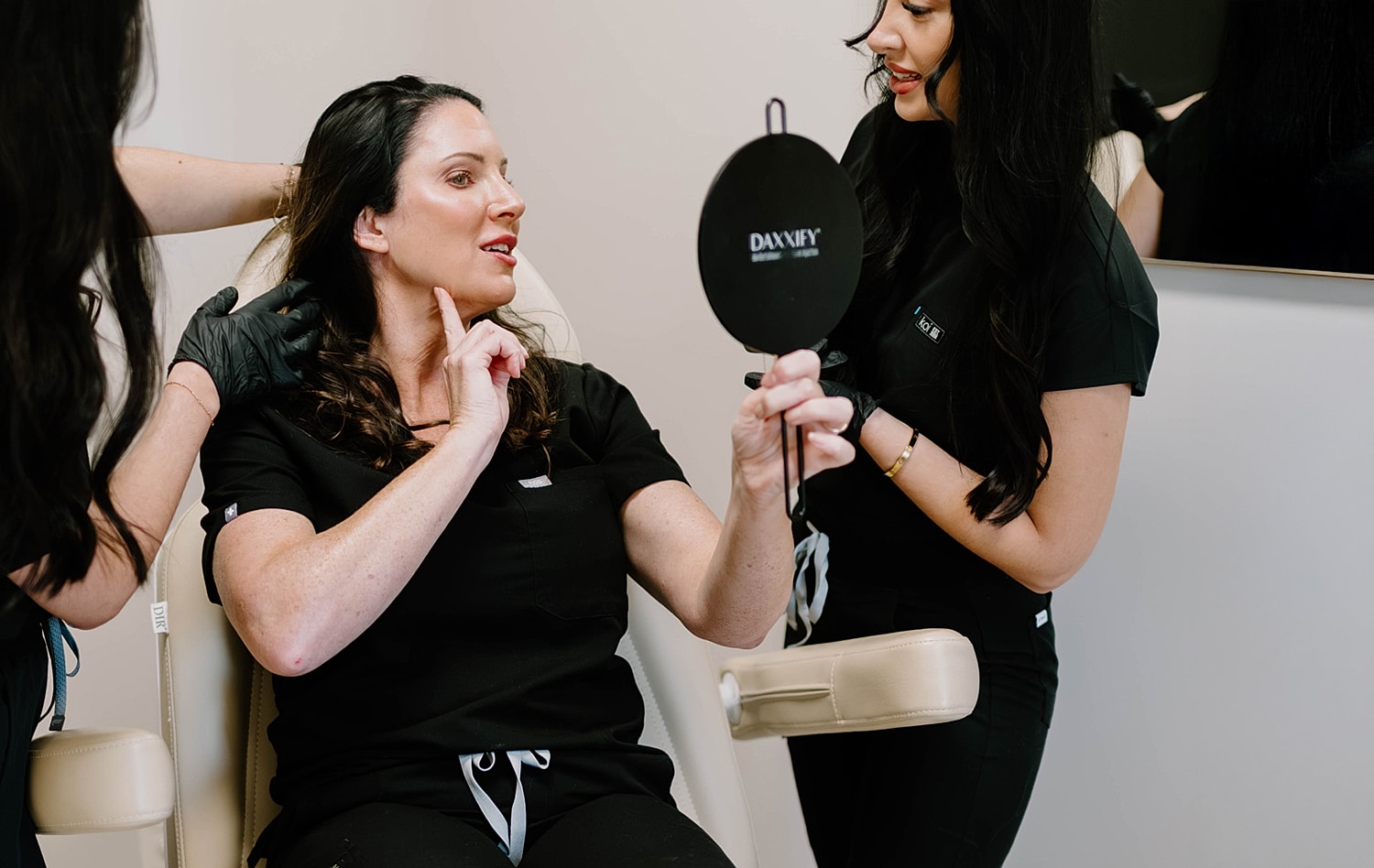 Client evaluating results in aesthetic treatment session.