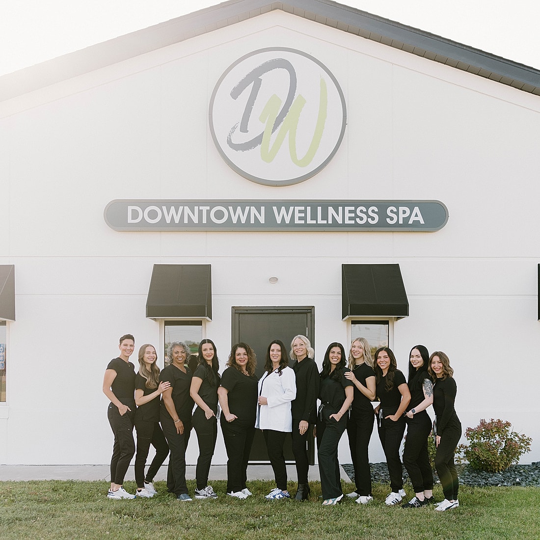 Wellness spa team in front of building.