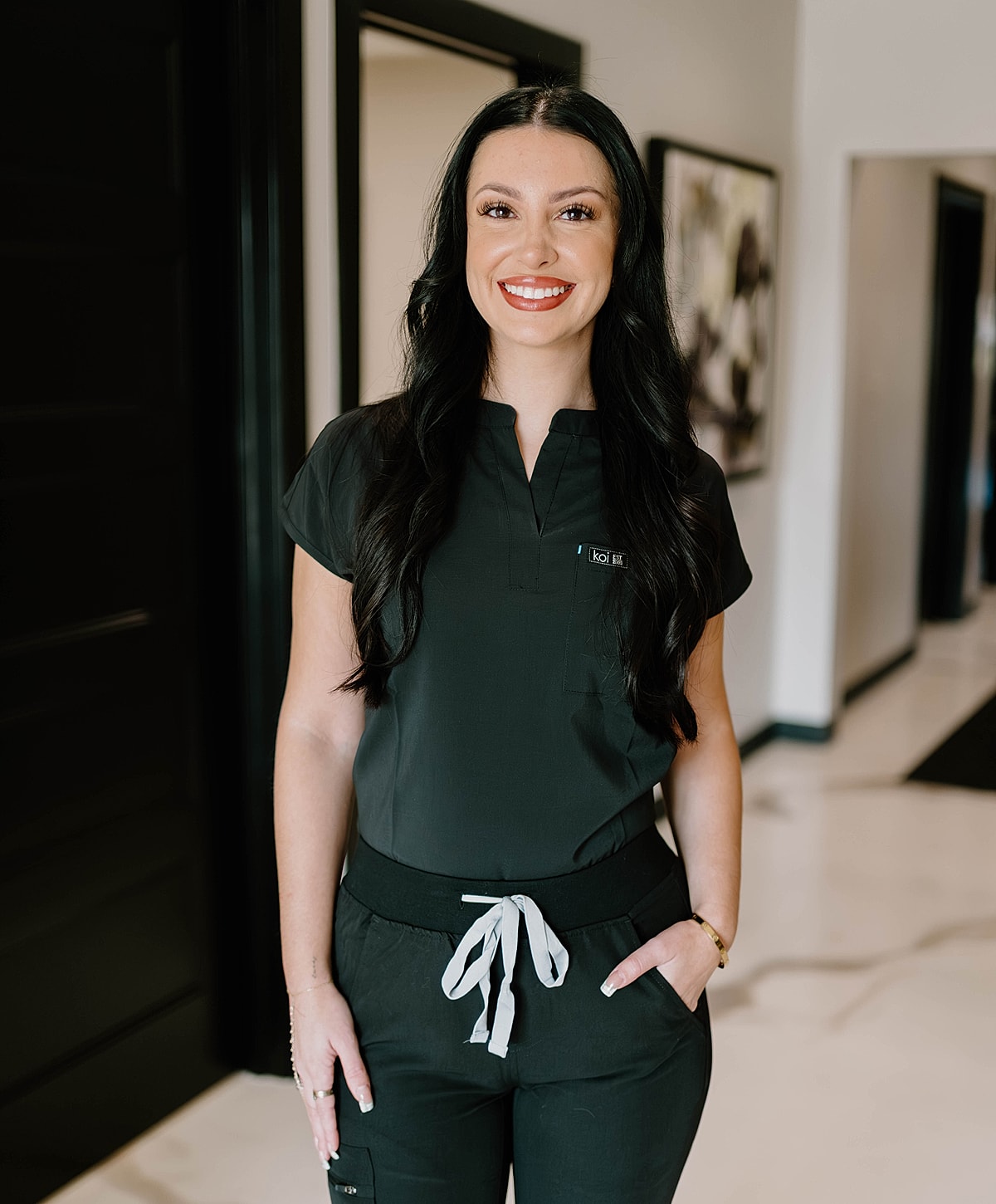 Smiling woman in medical scrubs indoors.