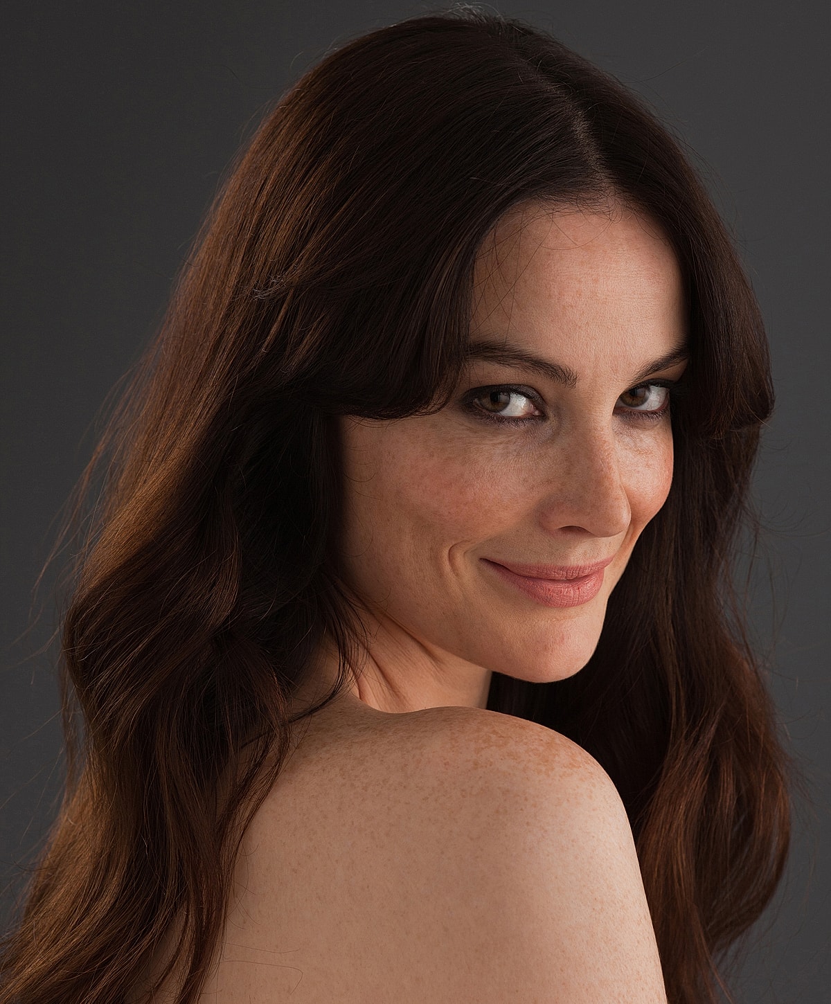 Smiling woman with long, wavy hair.