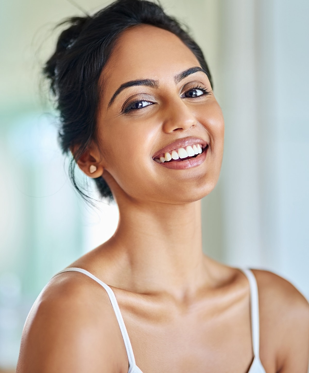 Smiling woman with dark hair and glowing complexion.
