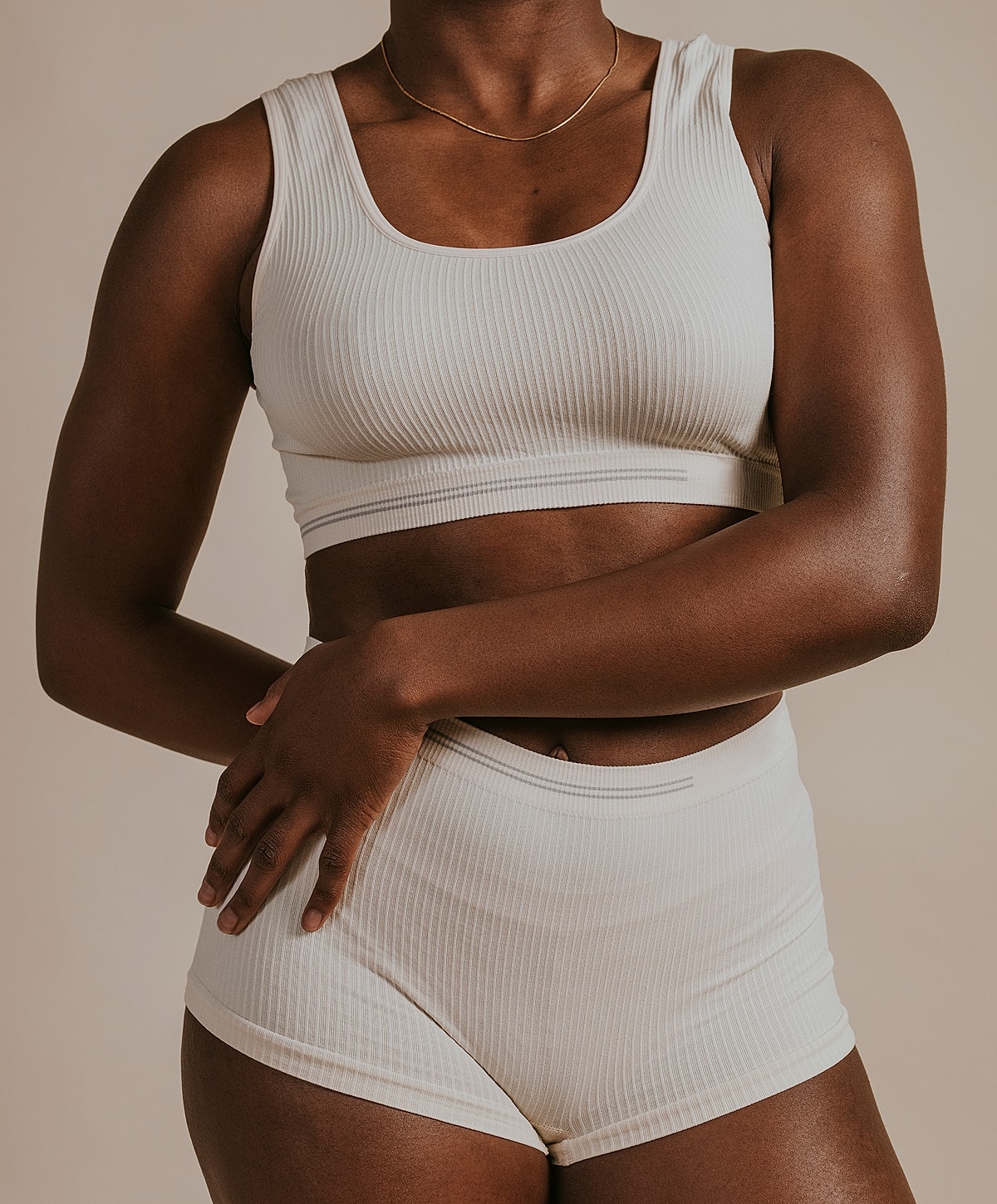 Model in cream ribbed activewear set.
