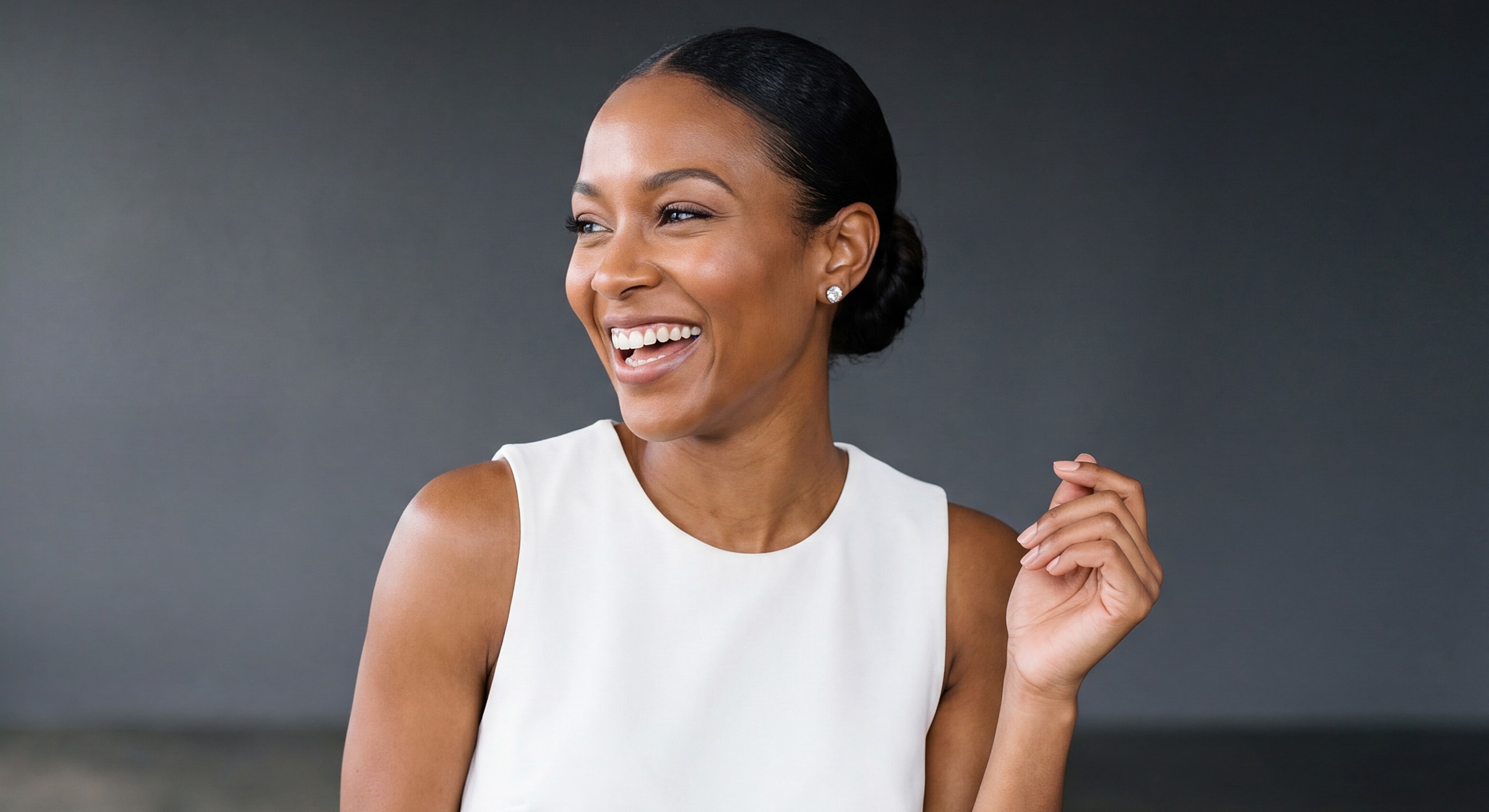 Smiling woman in a white dress, joyful expression.