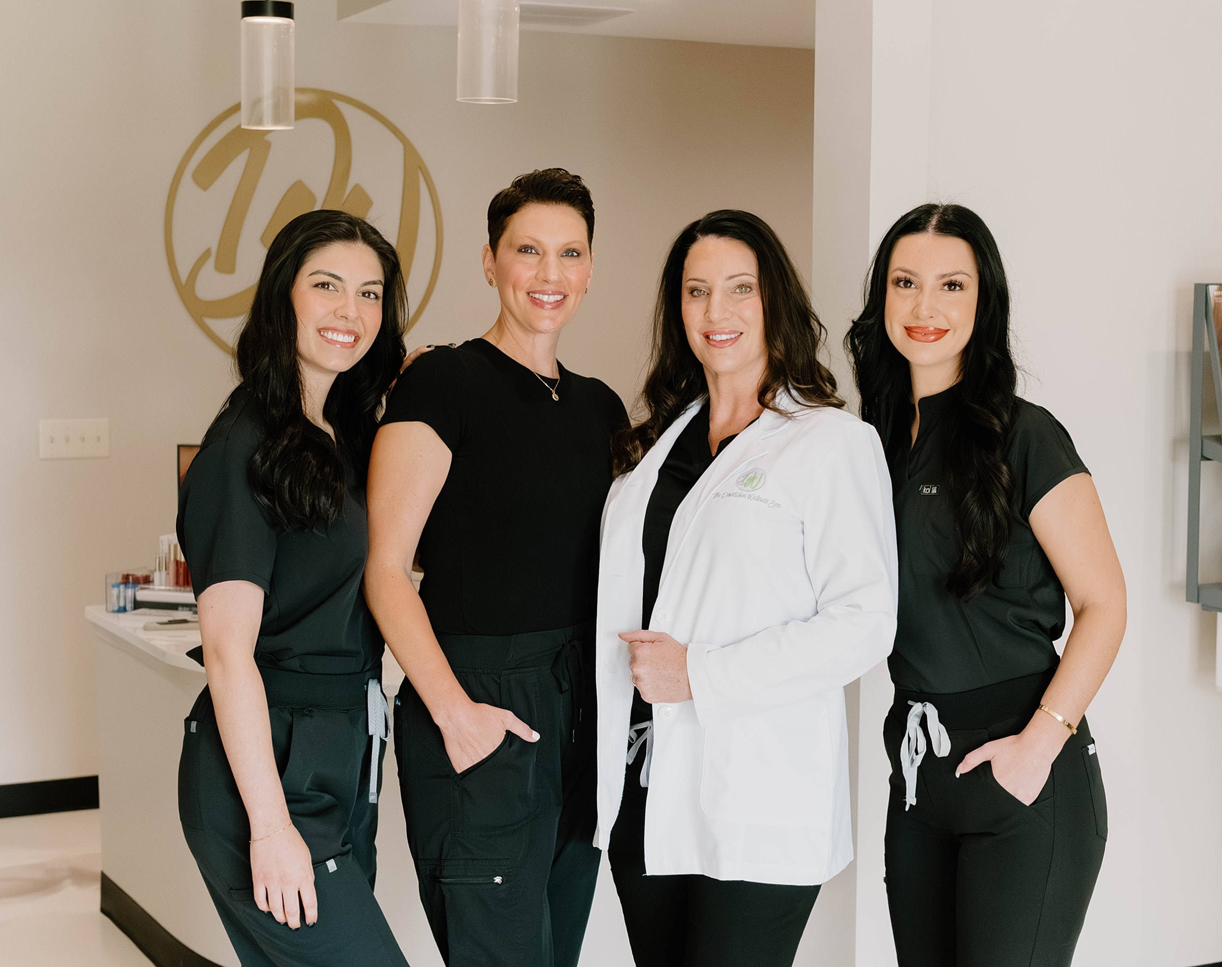 Four healthcare professionals posing together indoors.