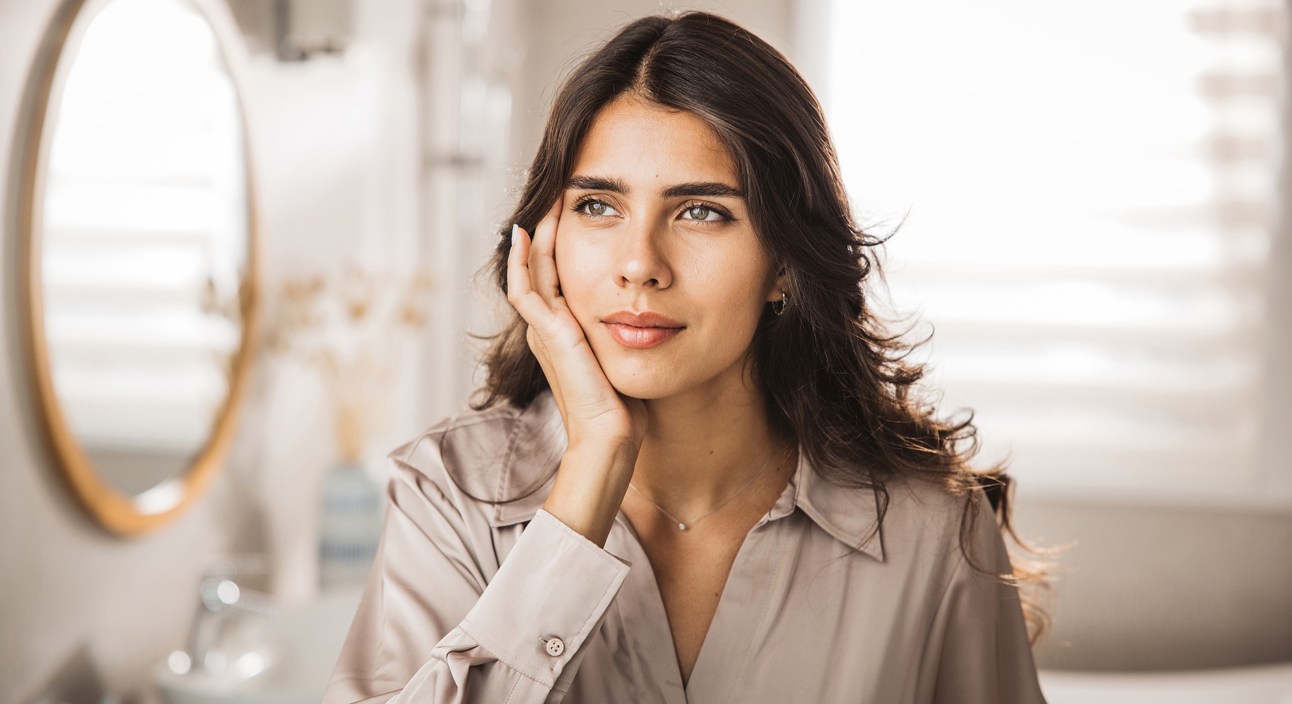 Thoughtful woman in a softly lit room.