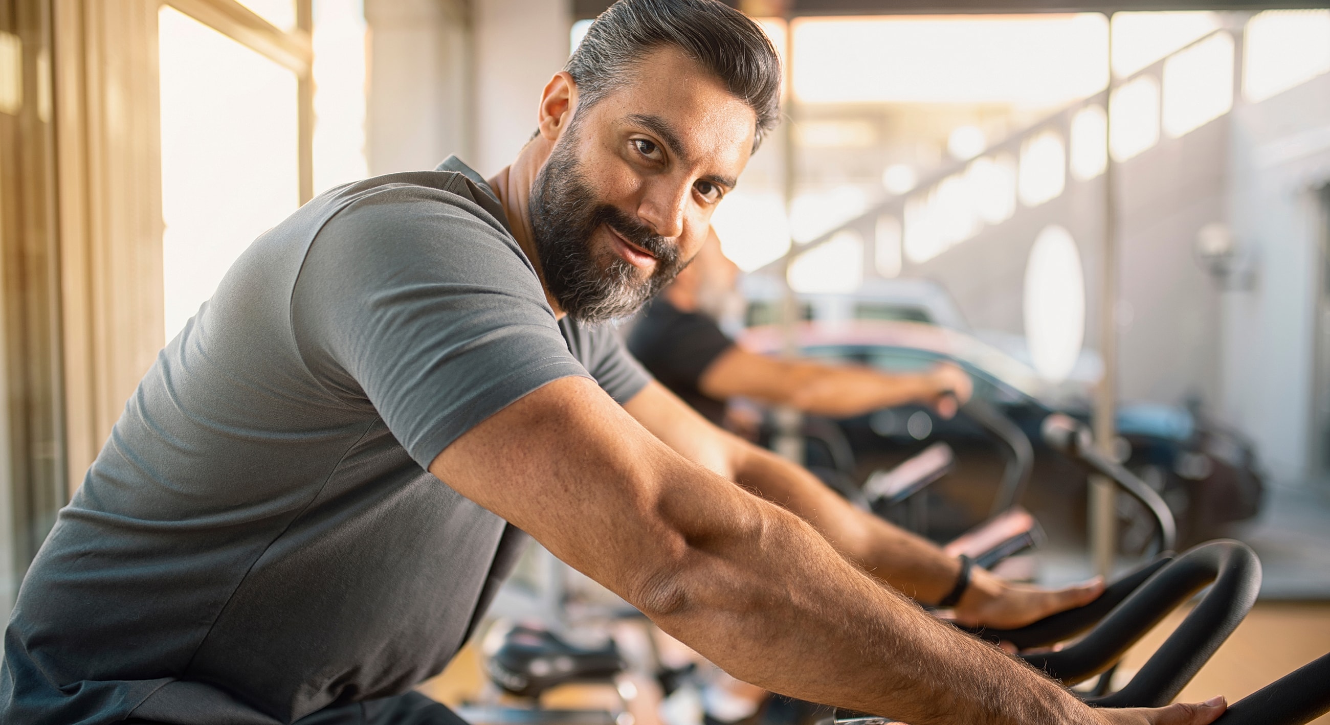 Man exercising on stationary bike in gym.